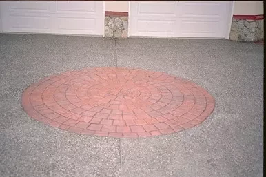 Circular red stamped feature set into exposed aggregate