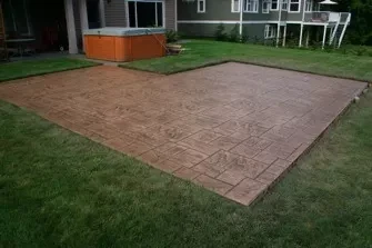 Rectangular stamped patio beside a lawn